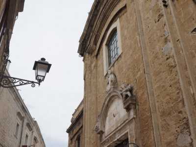 La facciata ripartita da lesene, appare con i suoi grandi mattoni marroni, quasi incavata all'interno di una larga cornice sagomata